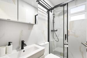 een badkamer met een wastafel en een douche bij Sé Apartamentos - Largo da Estação Apartments in Braga