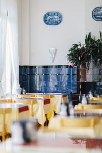 a dining room with tables and yellow chairs at Amsterdam Wiechmann Hotel in Amsterdam