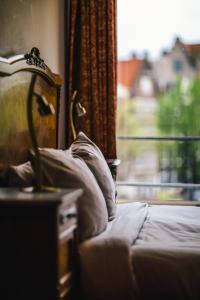 a bedroom with a bed and a window with a view at Amsterdam Wiechmann Hotel in Amsterdam