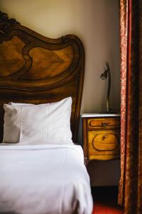 a bedroom with a bed with a wooden headboard and a night stand at Amsterdam Wiechmann Hotel in Amsterdam