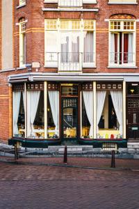 - un bâtiment avec des rideaux blancs devant dans l'établissement Amsterdam Wiechmann Hotel, à Amsterdam