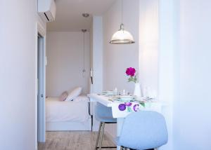 a white room with a table and a bed at APARTAMENTOS KRESALA - Vistas al mar in Getaria