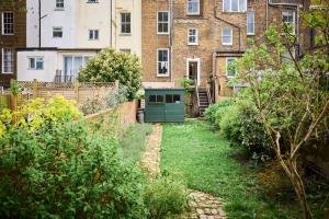 The Fulham Town House - Spacious 4BDR House with Garden في لندن: حديقة فيها باب أخضر أمام مبنى