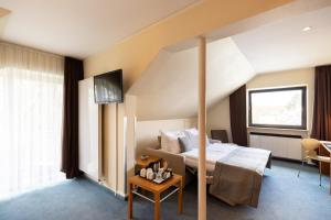 um quarto de hotel com uma cama e uma televisão em Select Hotel Silence Garden Köln em Colônia