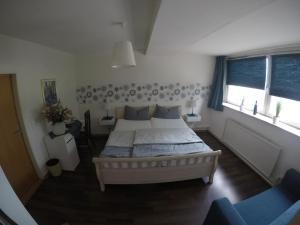 a bedroom with a large bed and two windows at Restaurant & Hotel Anglia in Steinbergkirche +1 photo