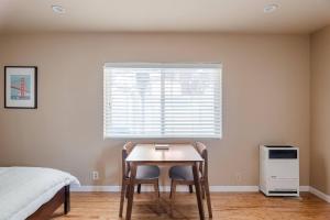 1 dormitorio con mesa y 2 sillas frente a una ventana en Modern studio within easy reach of Tech Giants en East Palo Alto