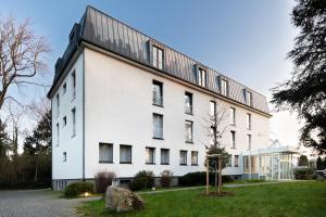 a white building with a black roof at Select Hotel Silence Garden Köln in Cologne