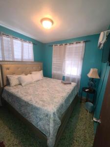 a bedroom with a bed with blue walls at Traditional Caribbean Abode near Beach and easy access to Freeway, Unit 6 in San Juan