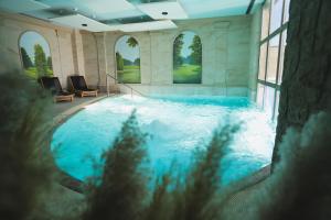 a large swimming pool in a large room with windows at Hotel Bernarda in Varaždinske Toplice