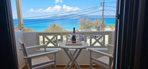 stół i krzesła na balkonie z widokiem na ocean w obiekcie Amalia Studios w miejscowości Agios Prokopios