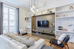 a living room with a couch and a tv at Apartment Le Marais by Studio prestige in Paris