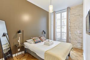 a bedroom with a bed and a large window at Apartment Le Marais by Studio prestige in Paris
