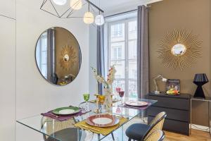 a dining room with a glass table and a mirror at Apartment Le Marais by Studio prestige in Paris
