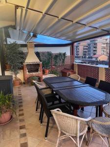 een patio met een tafel en stoelen en een open haard bij Stupendo appartamento sopra anfiteatro romano in Ventimiglia