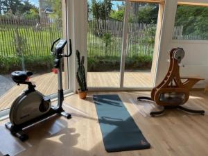 un gimnasio con cinta de correr y bicicleta estática en La Bernique blanche de Perros vue mer 4 personnes, en Perros-Guirec