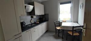 a kitchen with white cabinets and a table and a window at Labahn in Lohme