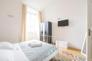 ローマにあるPraetorian apartmentの白いベッドルーム(ベッド1台、壁掛けテレビ付)