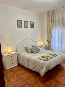 オルヒバにあるHuerta La Niña Arenasのベッドルーム1室(白い大型ベッド1台、ナイトスタンド2台付)