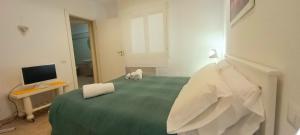 een slaapkamer met een groot groen bed en een televisie bij Miriam Casa Vacanze in Flumini di Quartu