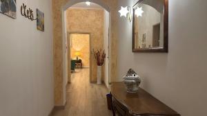 a hallway with a vase on a table and a mirror at Hotel Roma in Bologna
