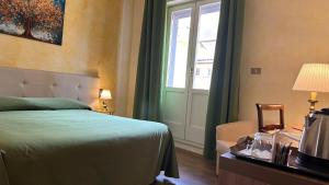 a bedroom with a bed and a window at Hotel Roma in Bologna
