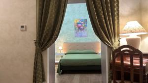 a bedroom with a bed and a window with curtains at Hotel Roma in Bologna