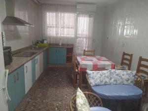a kitchen with a table and chairs and a kitchen with a sink at Casa del carpintero in Alhama de Murcia