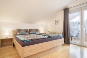 - une chambre avec un lit et une grande fenêtre dans l'établissement Haus Braun, à Wasserburg