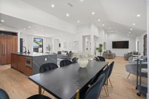 a living room with a table and chairs and a kitchen at Modern Luxurious Dream Home Mar Vista, 4BDRMs, 4Baths, Kid & Pet Friendly, 10min to the beach!! in Los Angeles