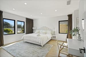 a white bedroom with a bed and two windows at Modern Luxurious Dream Home Mar Vista, 4BDRMs, 4Baths, Kid & Pet Friendly, 10min to the beach!! in Los Angeles