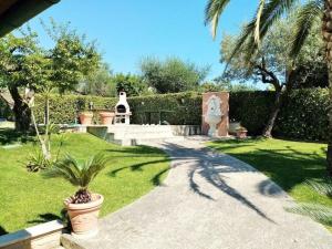 a garden with a palm tree and a statue at Villa fuer 6 Personen mit Schwimmbad in Mosciano SantʼAngelo