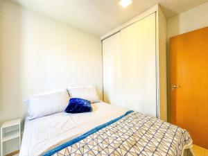 ein Schlafzimmer mit einem Bett mit einem blauen Kissen darauf in der Unterkunft APTO 1 quarto com Piscina, Metrô in Brasilia + 15 Fotos