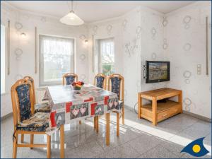 a dining room with a table and chairs at Haus Wartenberg Whg 01 in Reetzow