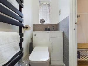 a small bathroom with a toilet and a sink at Cosy Modern Apartment Colchester in Colchester