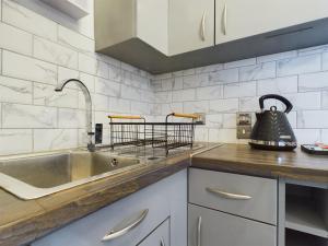 a kitchen with a sink and a tea kettle at Cosy Modern Apartment Colchester in Colchester