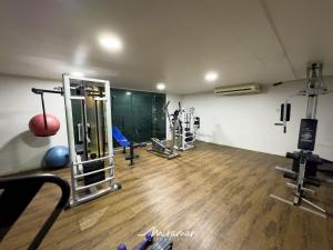 un gimnasio con varias máquinas en una habitación con suelo de madera en Blue Sunset en João Pessoa