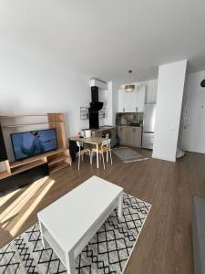 uma sala de estar com uma mesa branca e uma cozinha em Fancy apartament Silk district em Iaşi