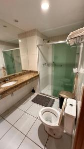 a bathroom with a toilet and a sink and a shower at Apartamento no tropical executive hotel com varanda, 1 cama de casal e 2 camas de solteiro in Manaus