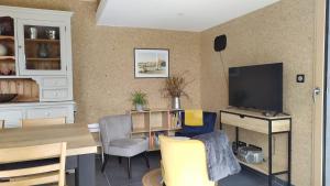 a living room with a table and a television at Gîte Le Charme d'Argent in Charmois-devant-Bruyères