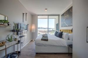a bedroom with a bed and a large window at Aircon Parking Washer Modern Ornate Waterfront in Cape Town