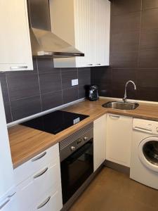 a small kitchen with a sink and a stove at Apartamento con vistas in Roquetas de Mar