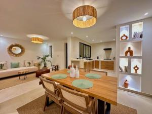 een eetkamer en een woonkamer met een houten tafel bij Villa d’architecte avec piscine in Agadir