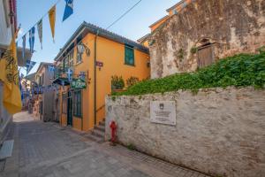 an alley with a yellow building and a red fire hydrant at Byron Hotel in Nafplio