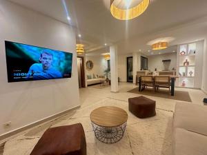 een woonkamer met een flatscreen-tv aan de muur bij Villa d’architecte avec piscine in Agadir