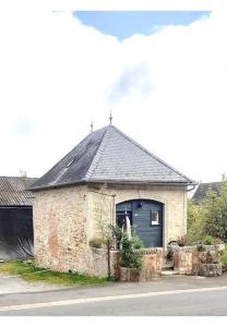 La Chapelle في Béduer: مبنى فيه باب ازرق فيه رجل واقف فيه