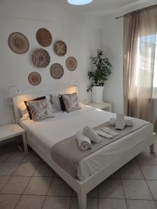 a bedroom with a large bed with towels on it at SEAgull apartments in Nea Peramos