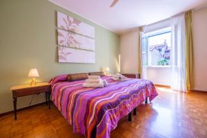 a bedroom with a bed with towels on it at Riva Dante Apartment - Happy Rentals in Riva del Garda