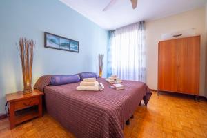 a bedroom with a bed with towels on it at Riva Dante Apartment - Happy Rentals in Riva del Garda