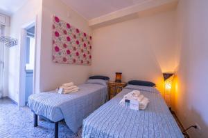 two twin beds in a bedroom with a painting on the wall at Riva Dante Apartment - Happy Rentals in Riva del Garda +21 photos