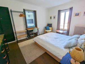 a bedroom with a bed and a desk and a mirror at Les Tilleuls 4 in Saint-Gingolph +9 photos
